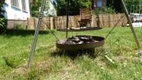 a fire pit in a yard with a grill at Alte Schule in Tambach-Dietharz