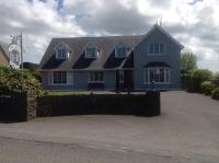 una casa azul con una valla delante en The Well Bed &amp; Breakfast, en Clonakilty