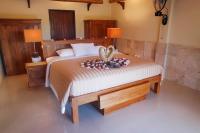 a bedroom with a bed with two swans on it at Rinjani Lodge in Senaru