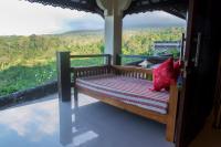 a bench on the balcony of a house at Rinjani Lodge in Senaru