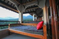 a bed on a balcony with a view of the mountains at Rinjani Lodge in Senaru