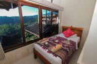 a bedroom with a bed and a large window at Rinjani Lodge in Senaru