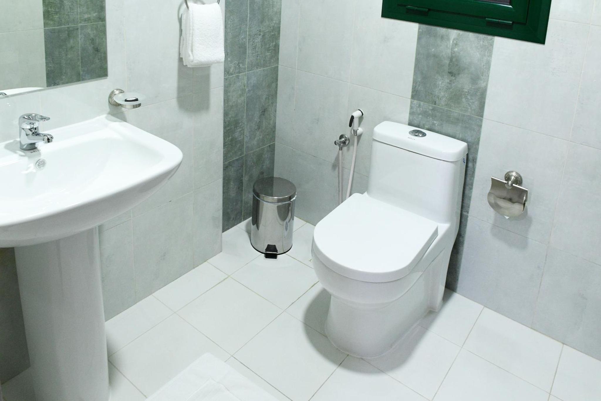 a bathroom with a toilet and a sink at Montana Tower in Manama