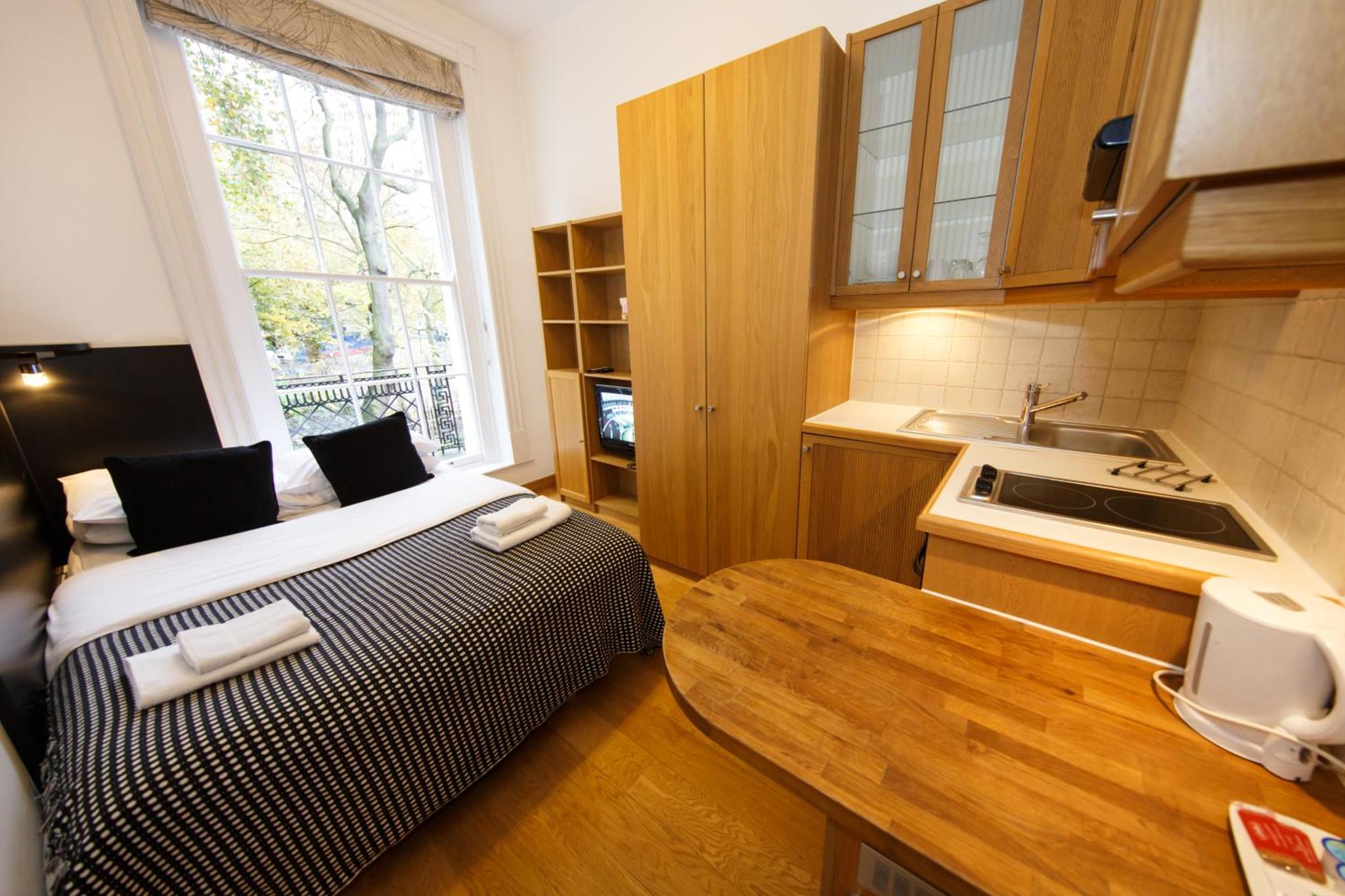a small kitchen with a bed and a sink at Studios2Let in London