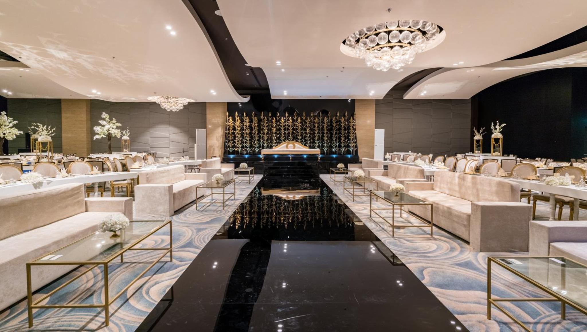 a banquet hall with tables and chairs and a chandelier at Solymar Hotel & Beach in Manama +76 photos