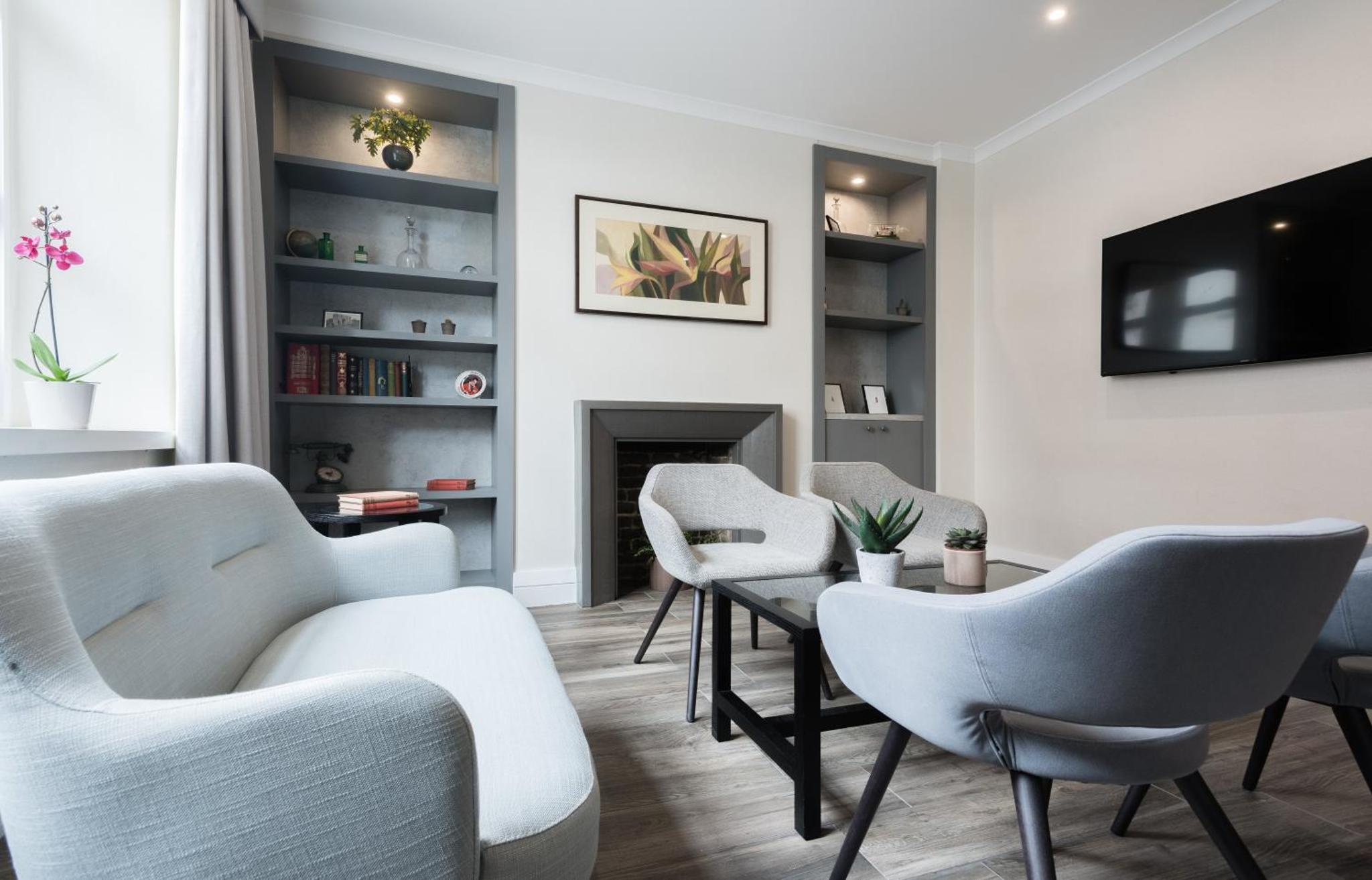 a living room with chairs and a fireplace at Blandford Hotel in London