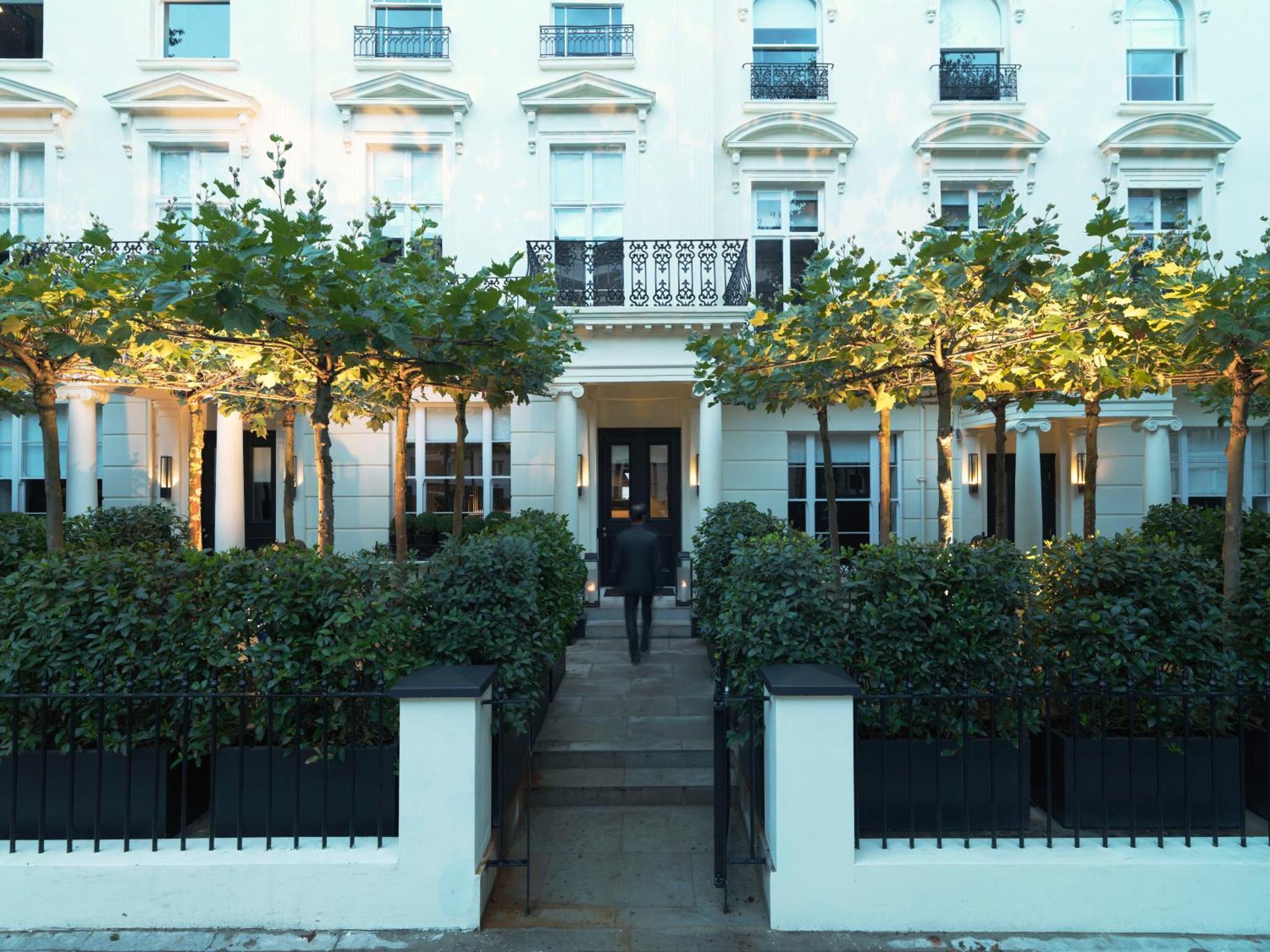 a man walking down the stairs in front of a white building at La Suite West - Hyde Park in London
