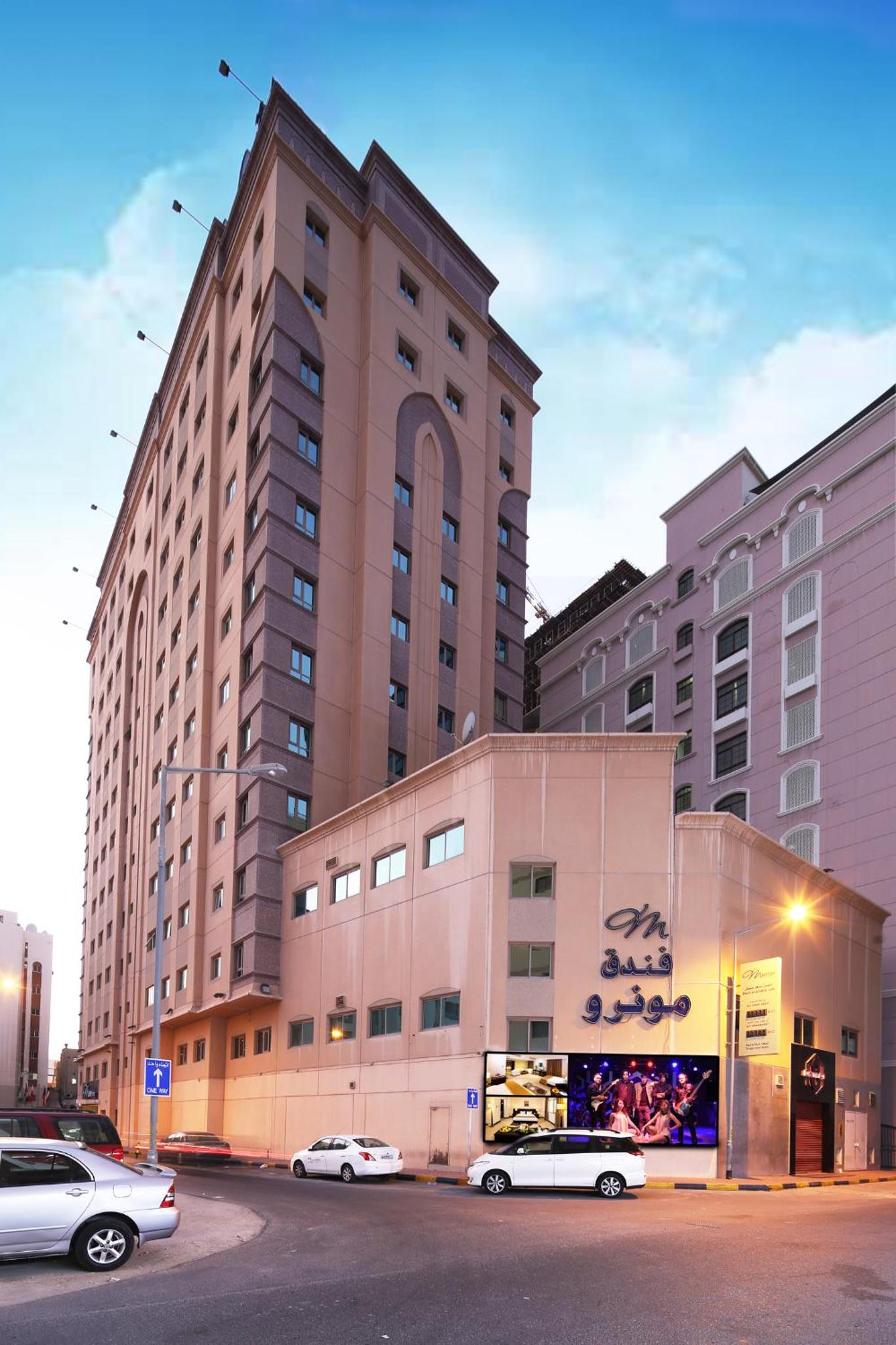 a large building with cars parked in front of it at Monroe Hotel & Suites in Manama