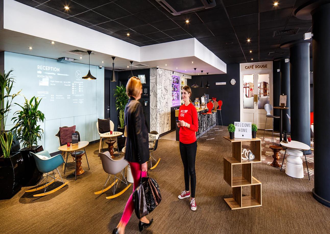 two women are standing in a room with furniture at ibis London Greenwich in London