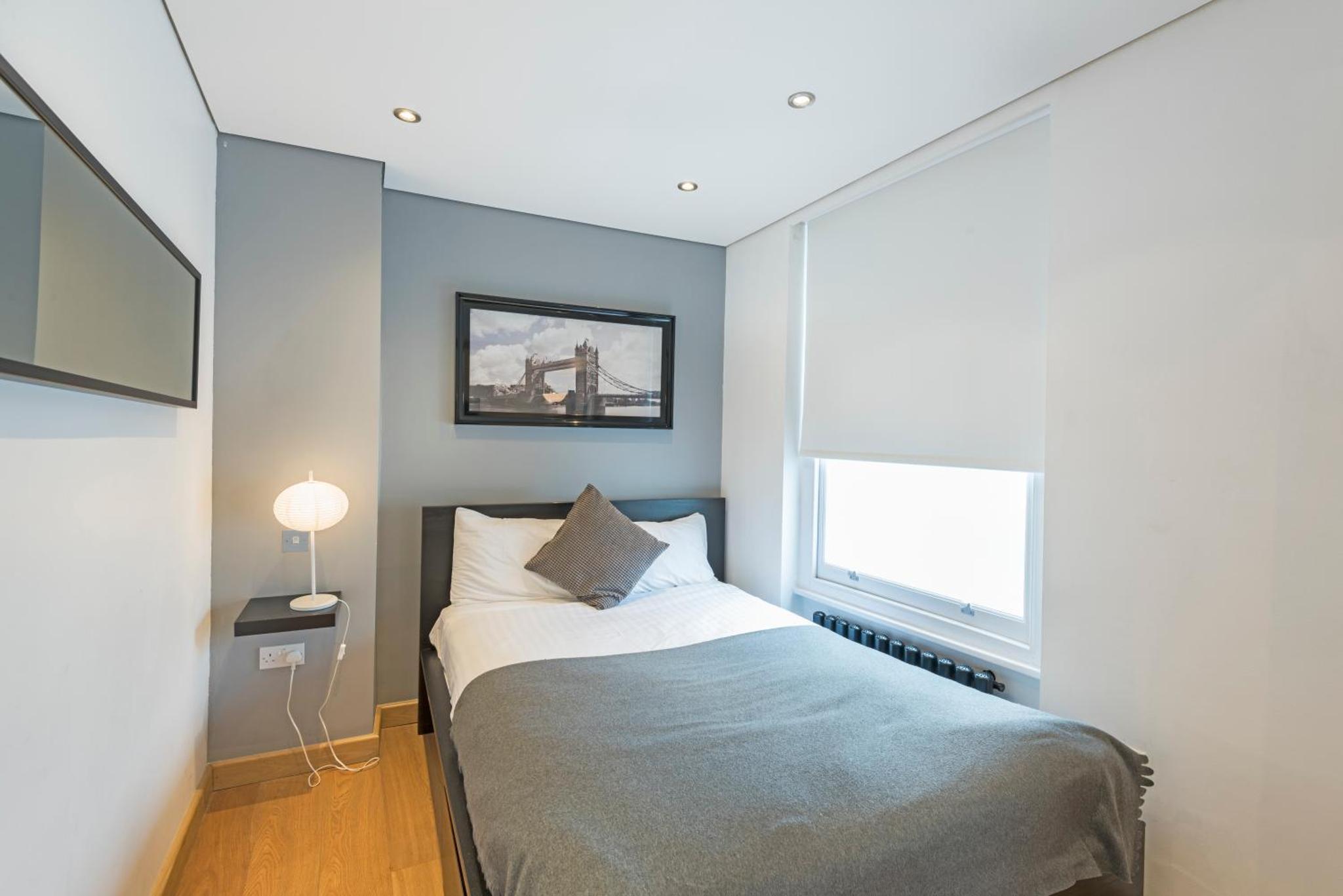 a bedroom with a bed and a window at St Paul's by Excel Apartments in London