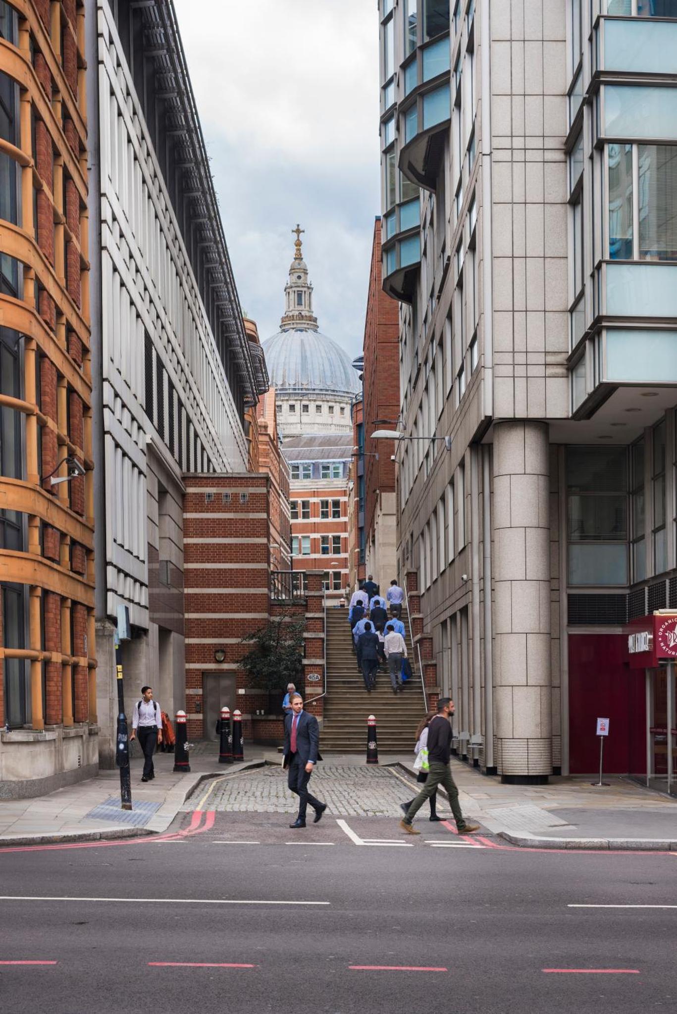 a group of people crossing a street in a city at St Paul's by Excel Apartments in London