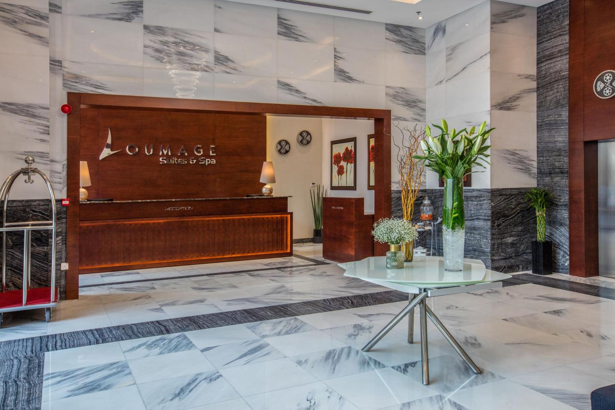 a lobby with a piano and a table at Loumage S Suites and Spa in Manama