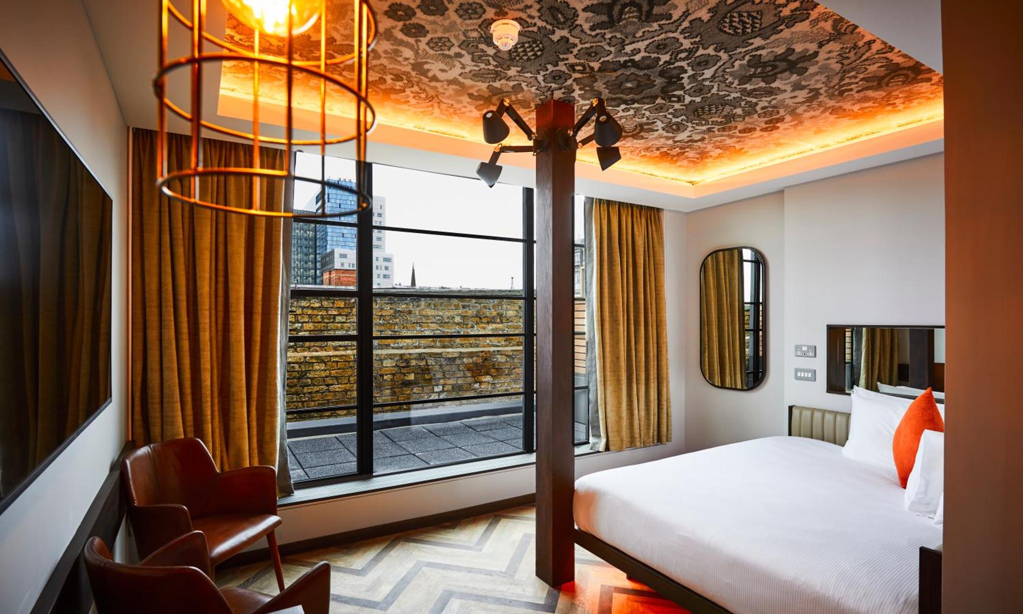 a hotel room with a bed and a large window at New Road Hotel in London