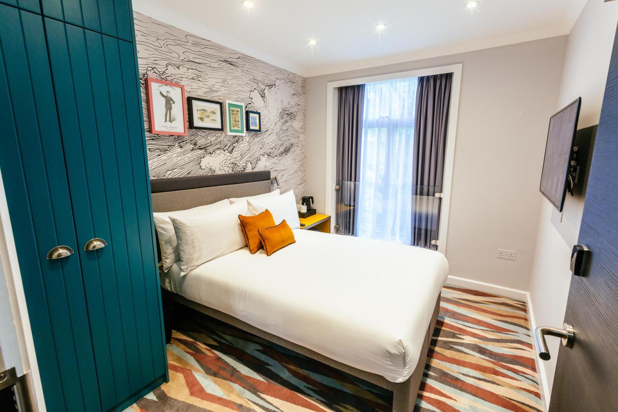 a bedroom with a bed and a green door at Oliver Plaza Hotel in London