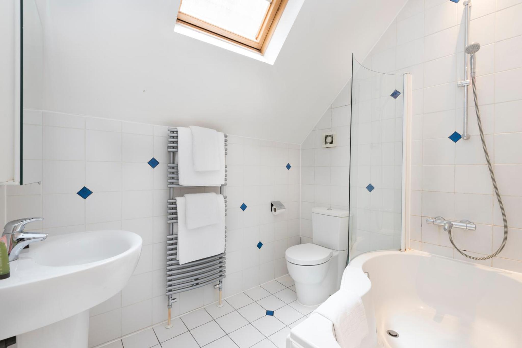 a white bathroom with a tub sink and a toilet at St Paul's by Excel Apartments in London +20 photos