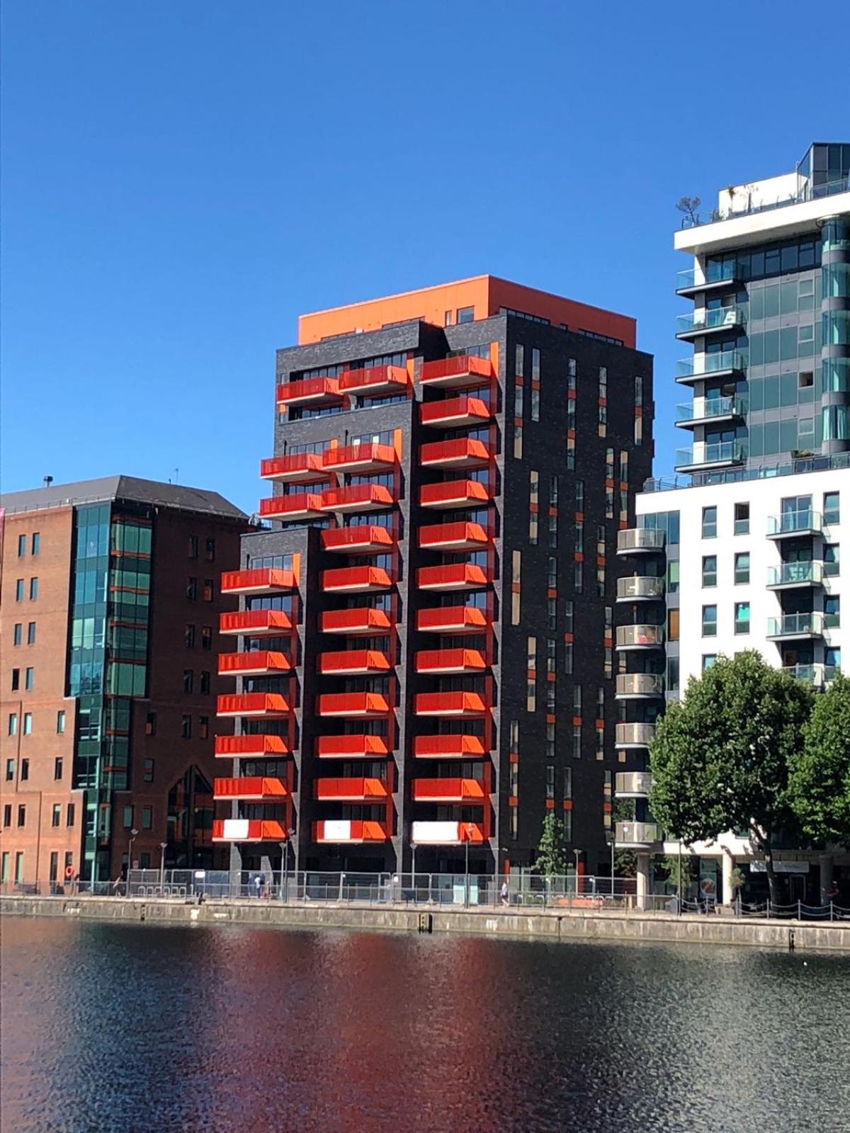 a group of tall buildings next to a body of water at Clover Court by Aeria Apartments in London