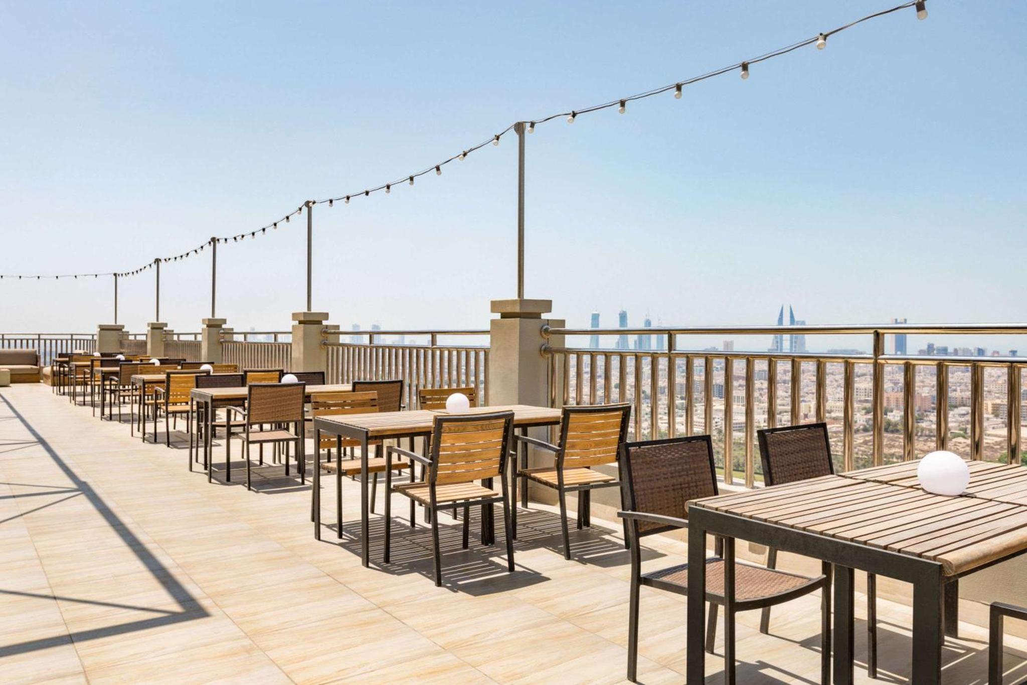a row of tables and chairs on a roof at Wyndham Garden Manama in Manama