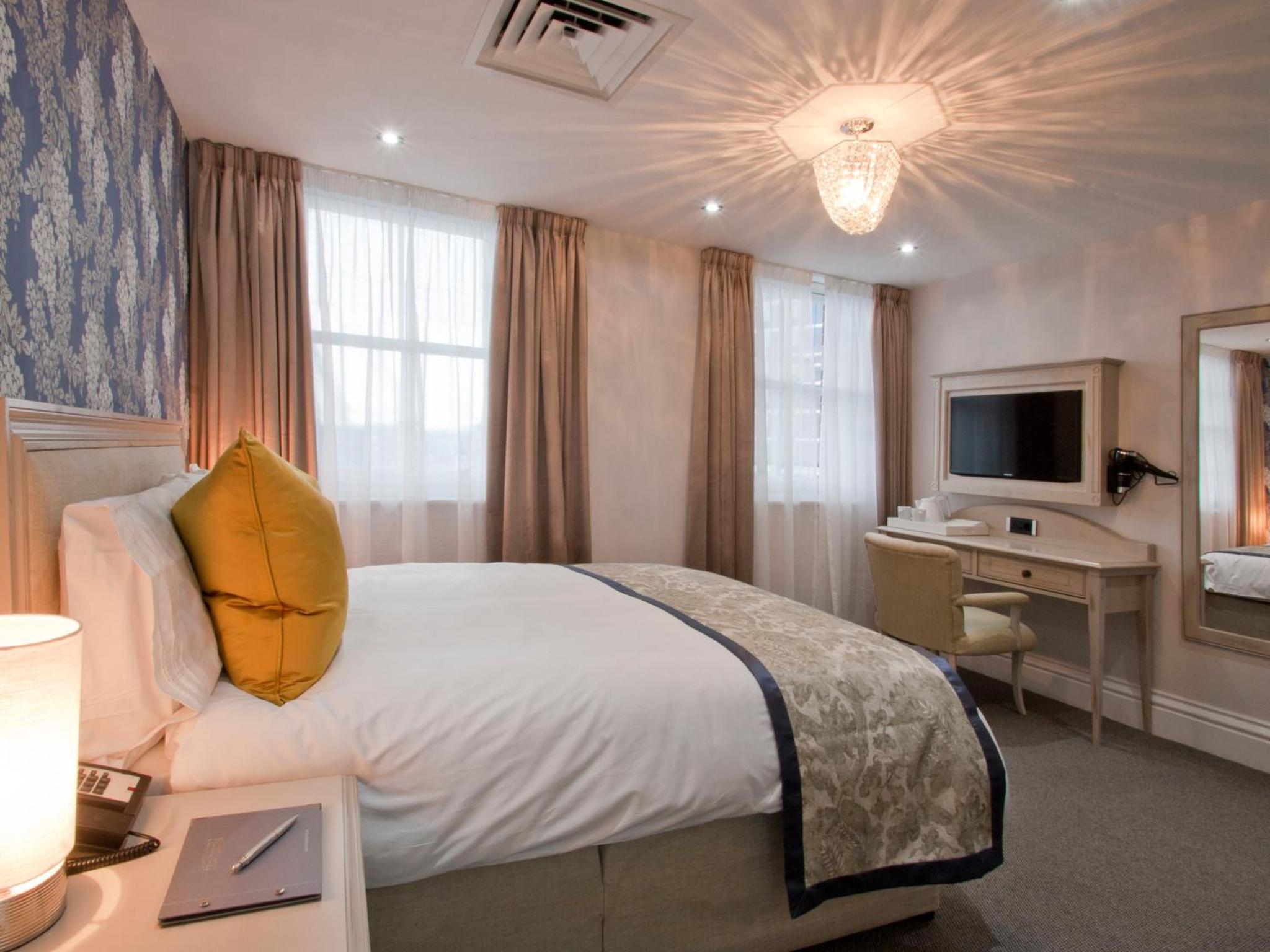 a hotel room with a bed and a desk and a television at W12 Rooms in London
