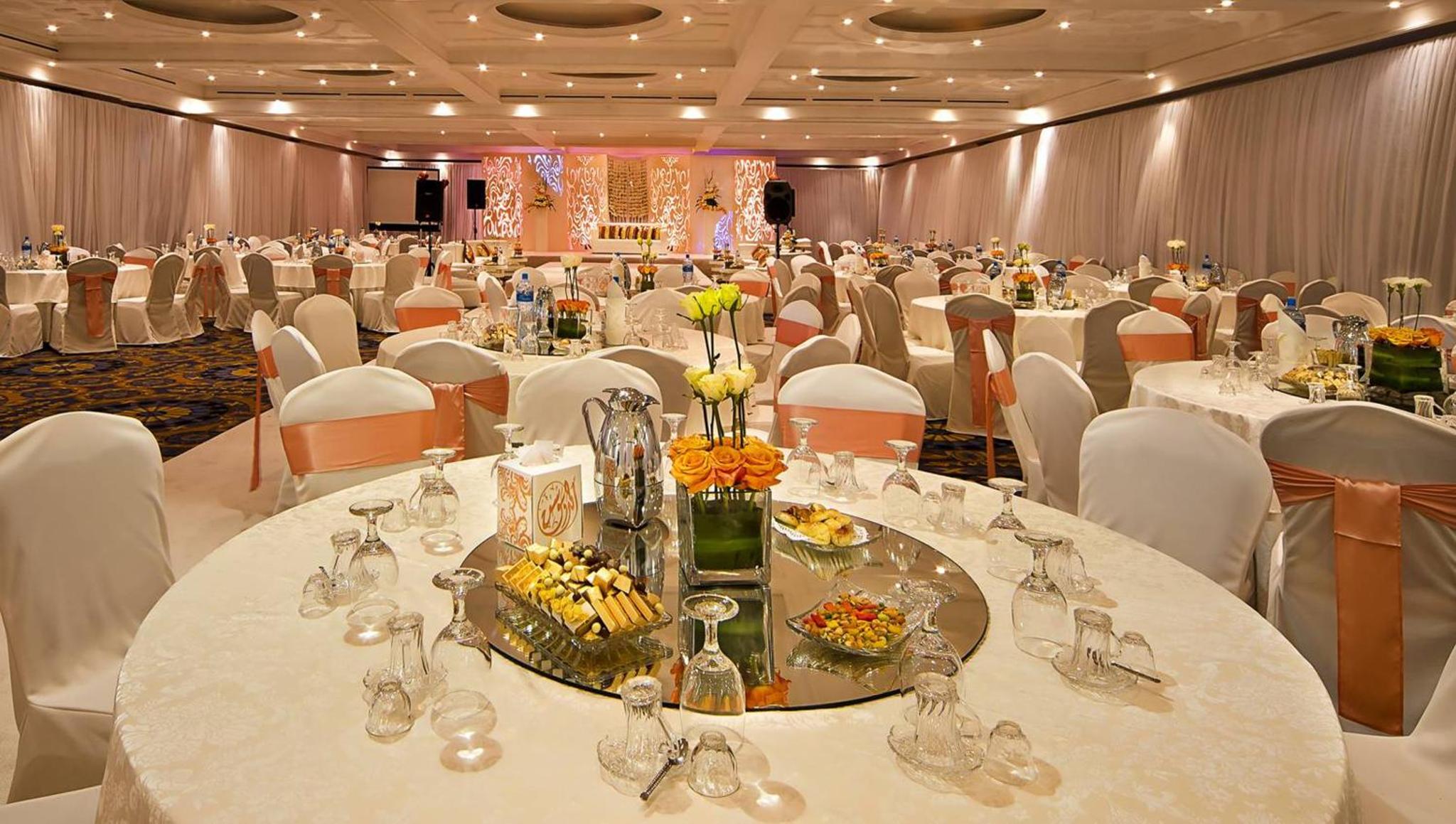 a large banquet hall with white tables and white chairs at Gulf Executive Residence in Manama +29 photos