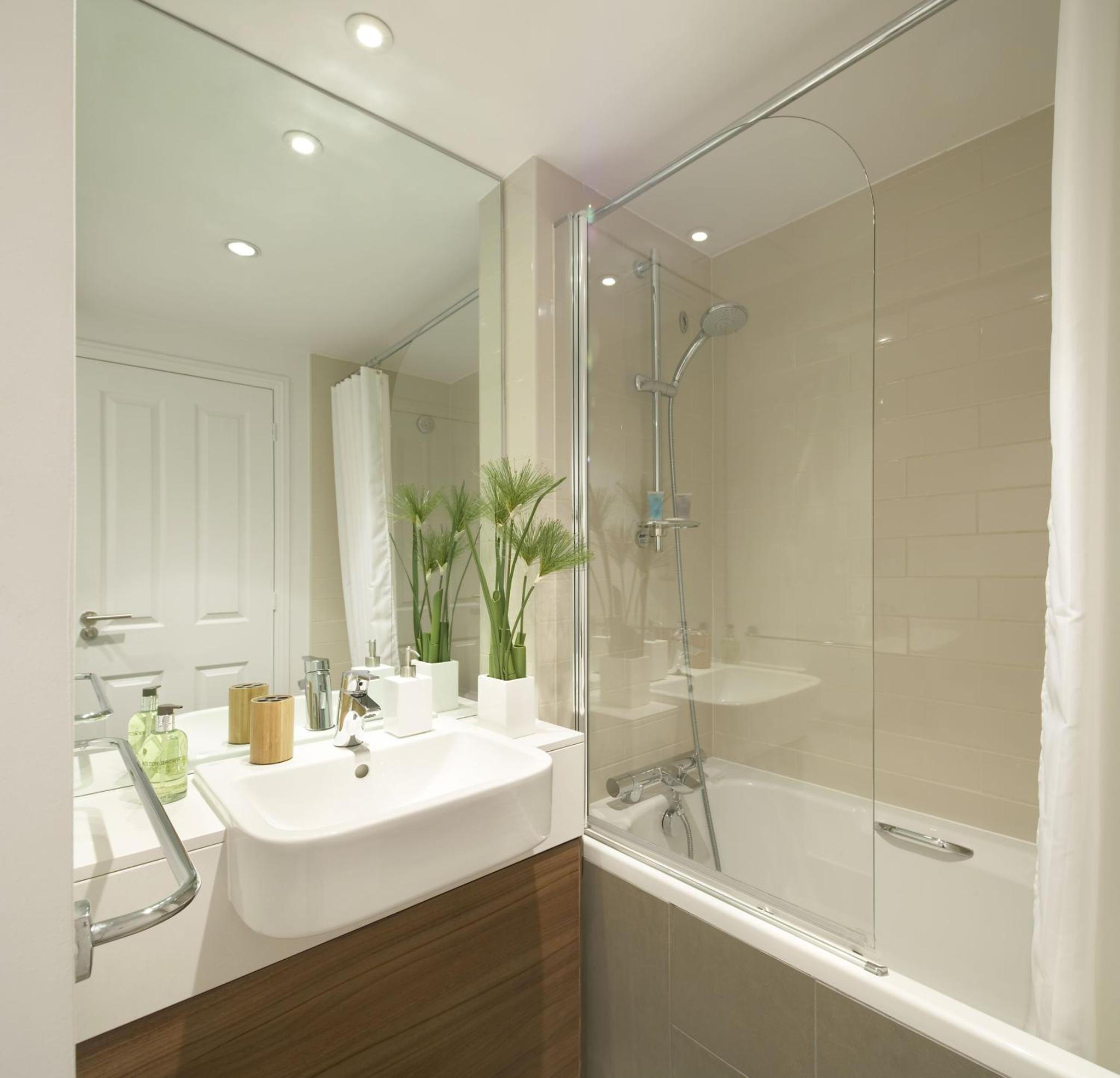 a white bathroom with a sink and a shower at Citadines South Kensington London in London