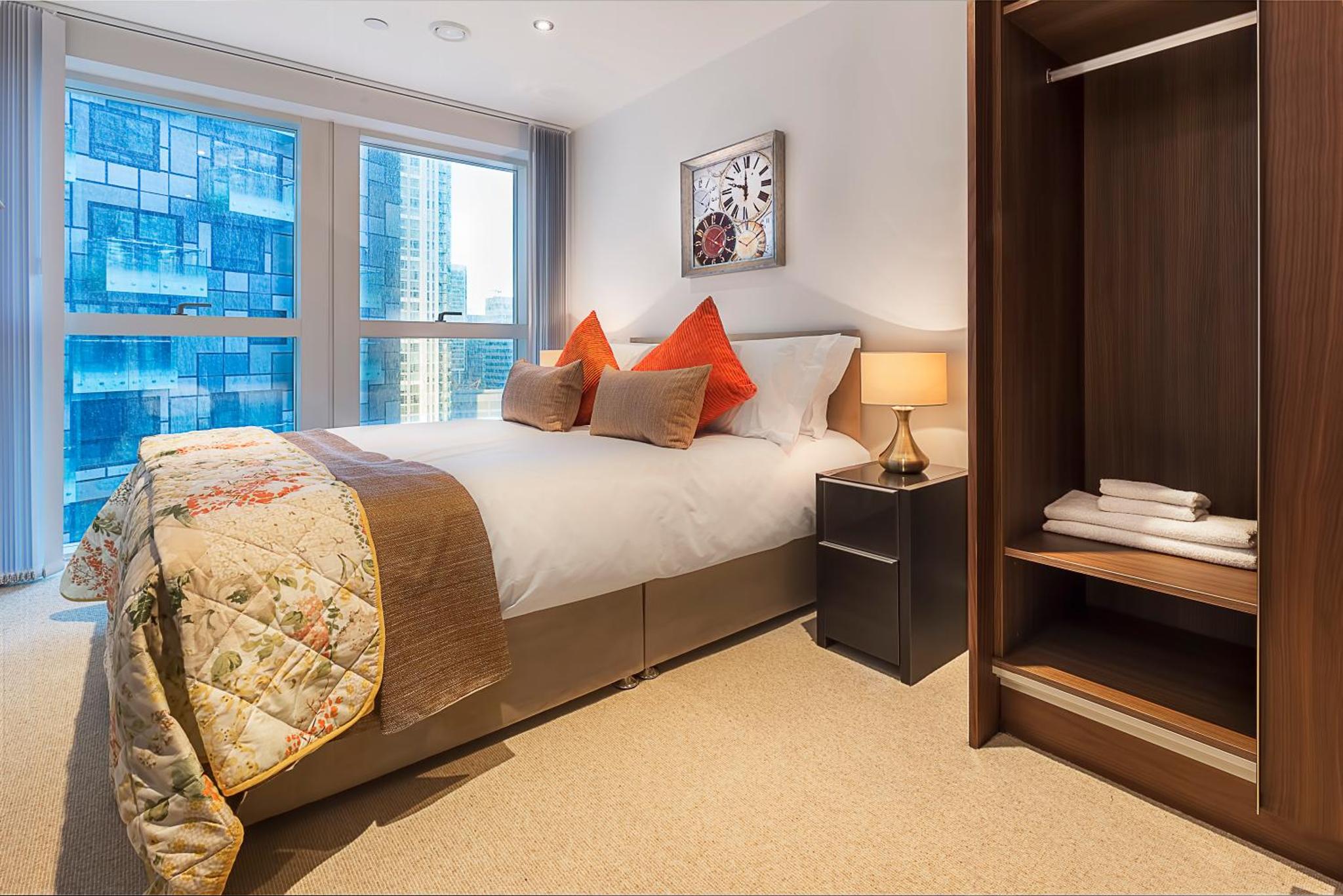 a bedroom with a bed and a large window at Clover Court by Aeria Apartments in London