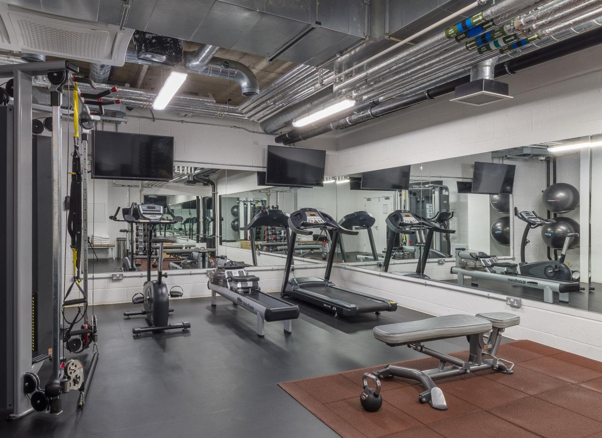 a gym with several treadmills and exercise machines at Leman Locke in London