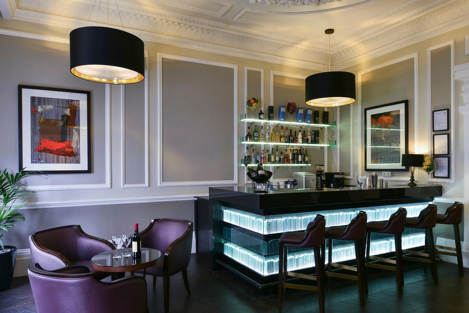 a bar in a restaurant with purple chairs at Fraser Suites Queens Gate in London