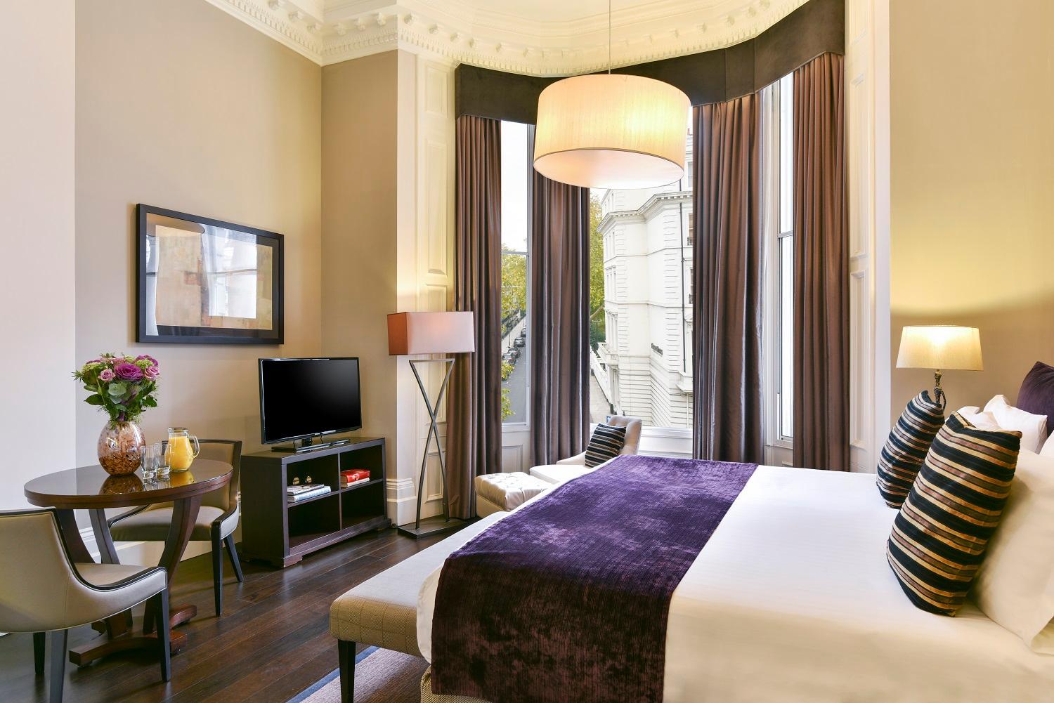 a hotel room with a large bed and a television at Fraser Suites Queens Gate in London