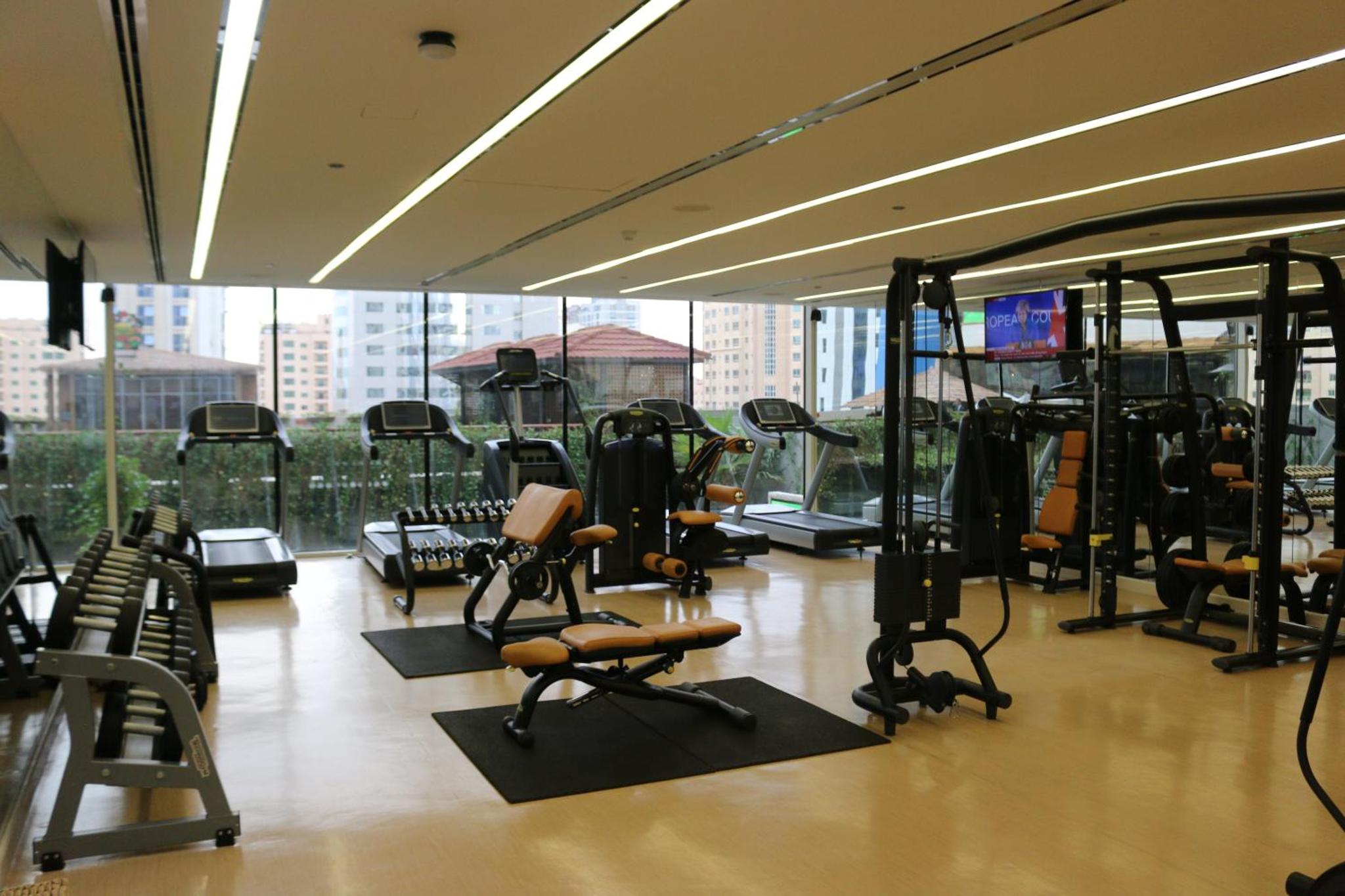 a gym with several treadmills and exercise bikes at Elite Crystal Hotel in Manama