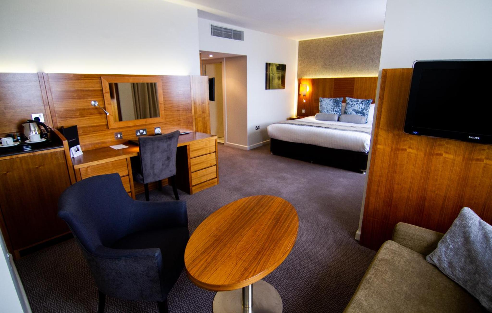 a hotel room with a desk and a bed at Blakemore Hyde Park in London