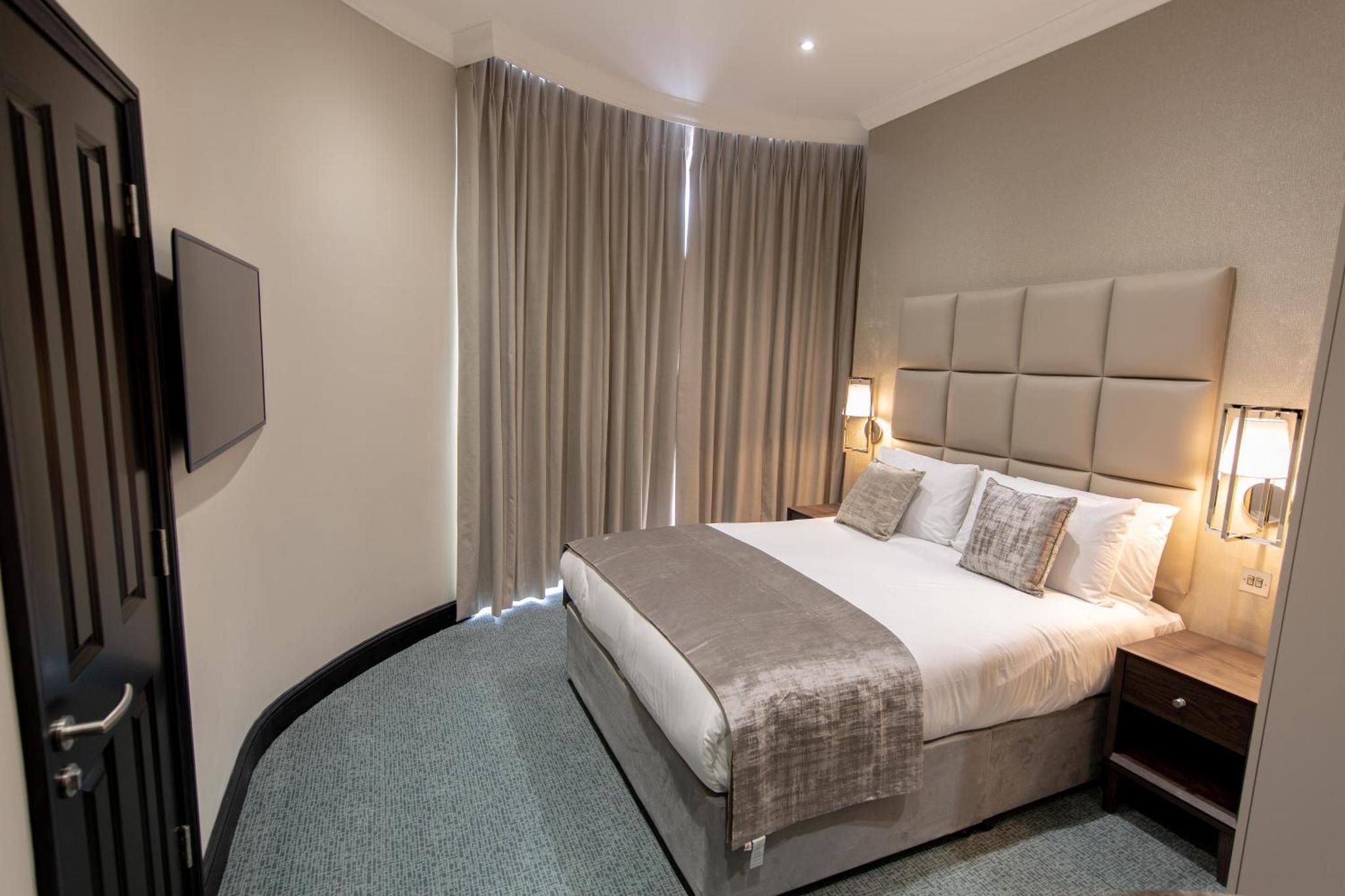 a hotel room with a bed and a window at The Crescent Hyde Park in London +11 photos