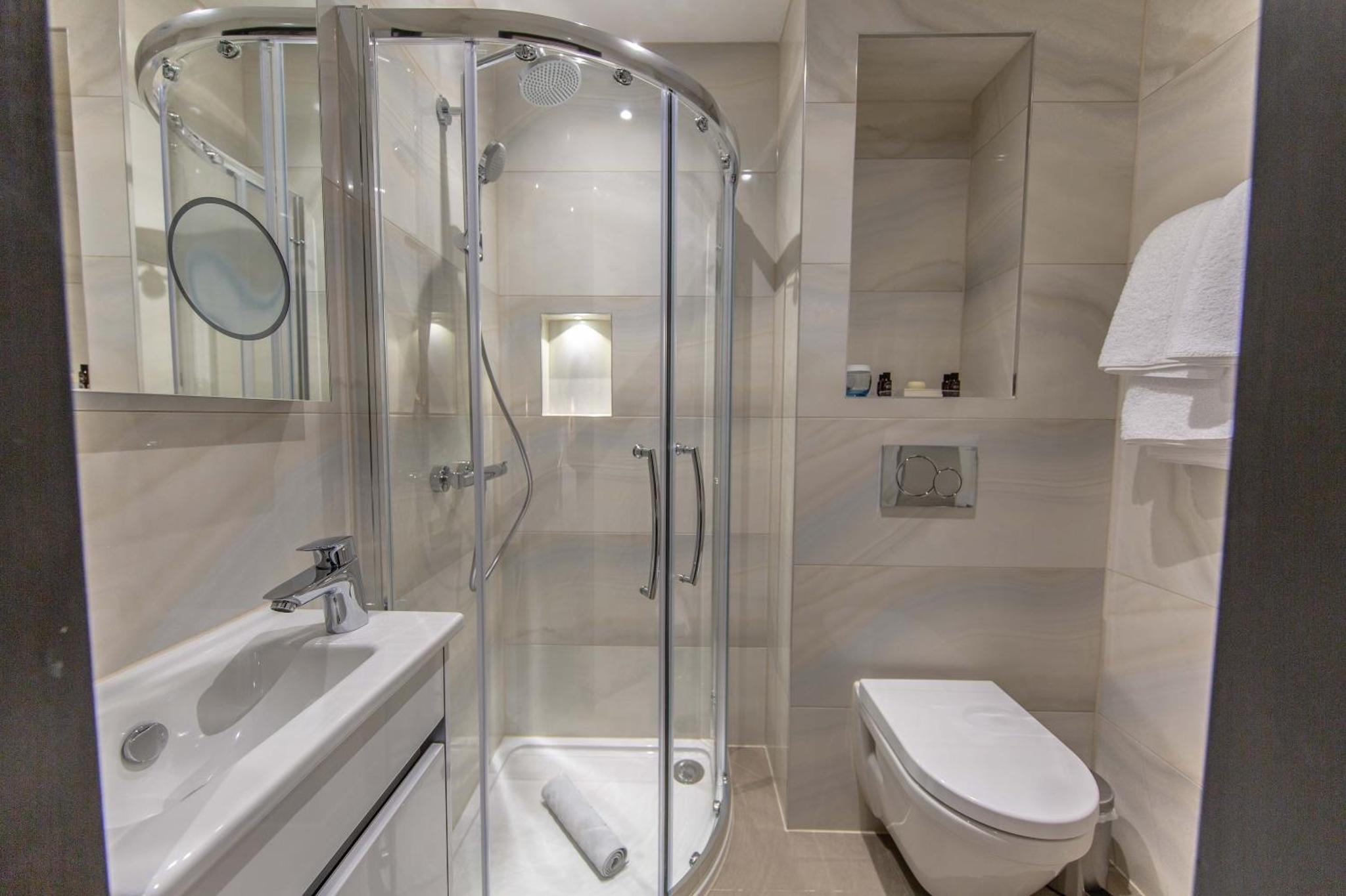 a bathroom with a shower and a toilet and a sink at The Crescent Hyde Park in London