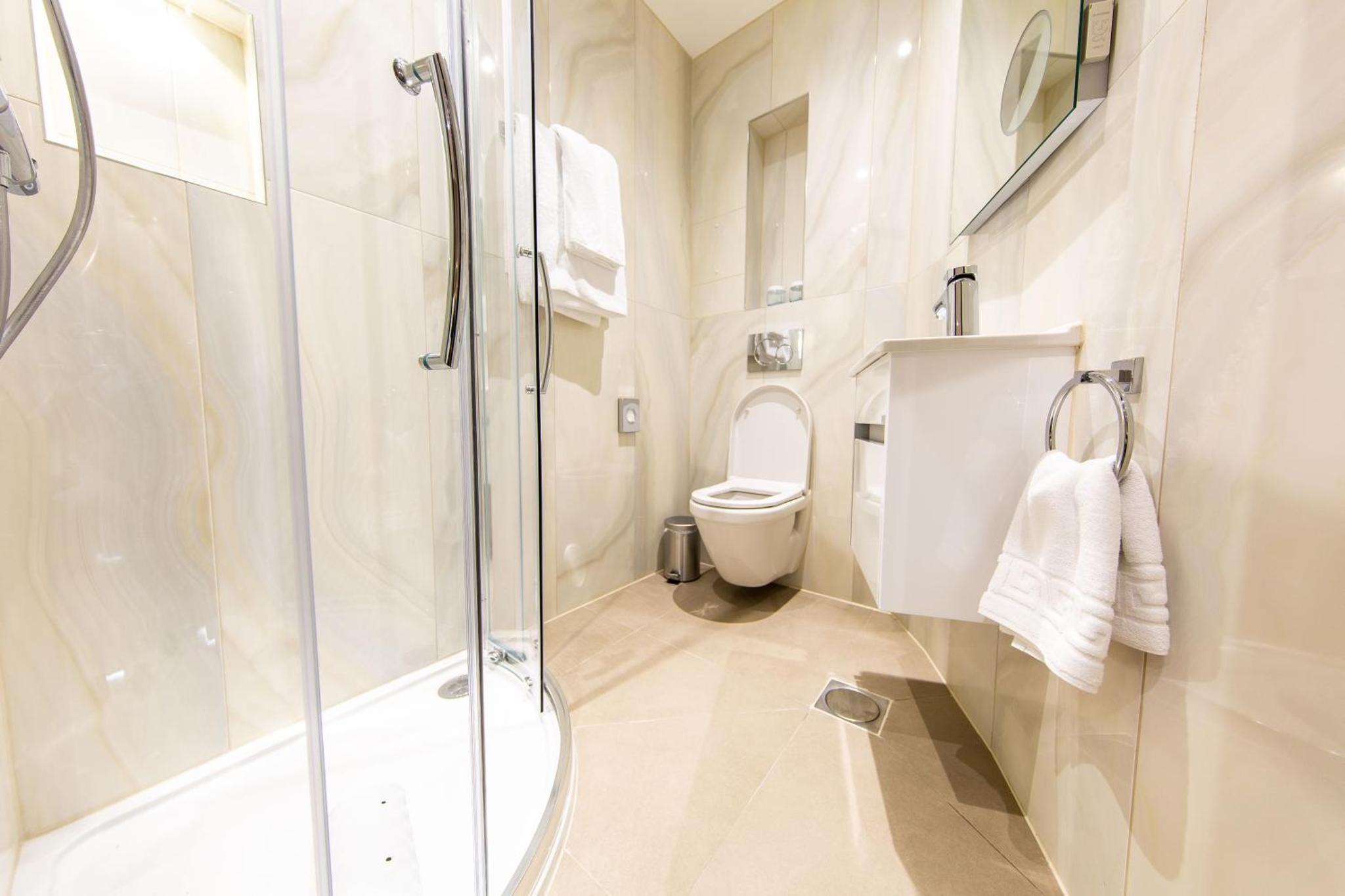 a bathroom with a shower and a toilet at The Crescent Hyde Park in London
