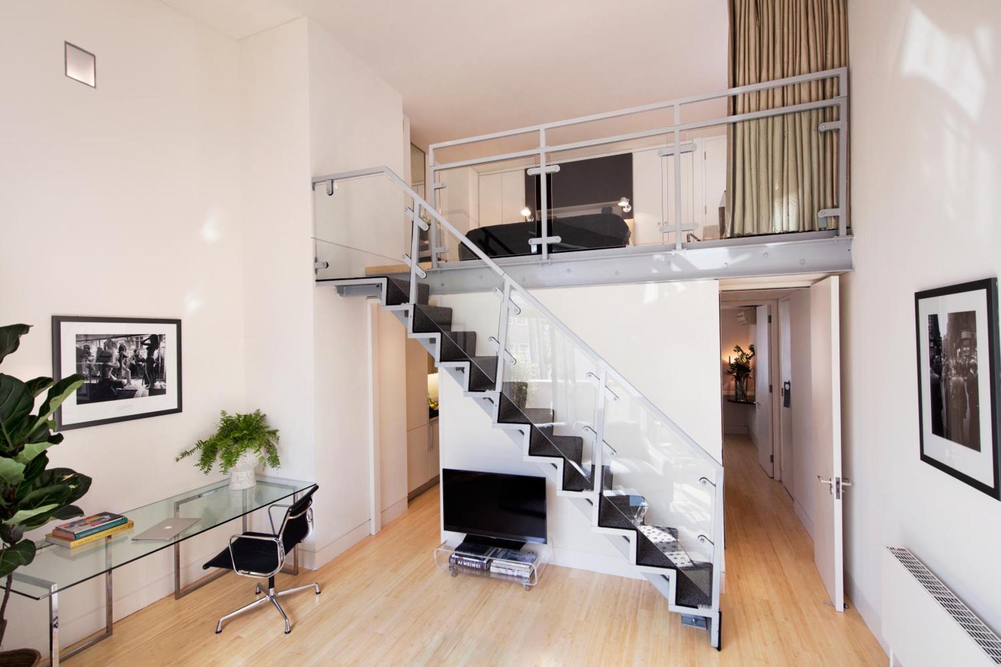 a spiral staircase in a living room with a desk at No.5 Maddox Street in London