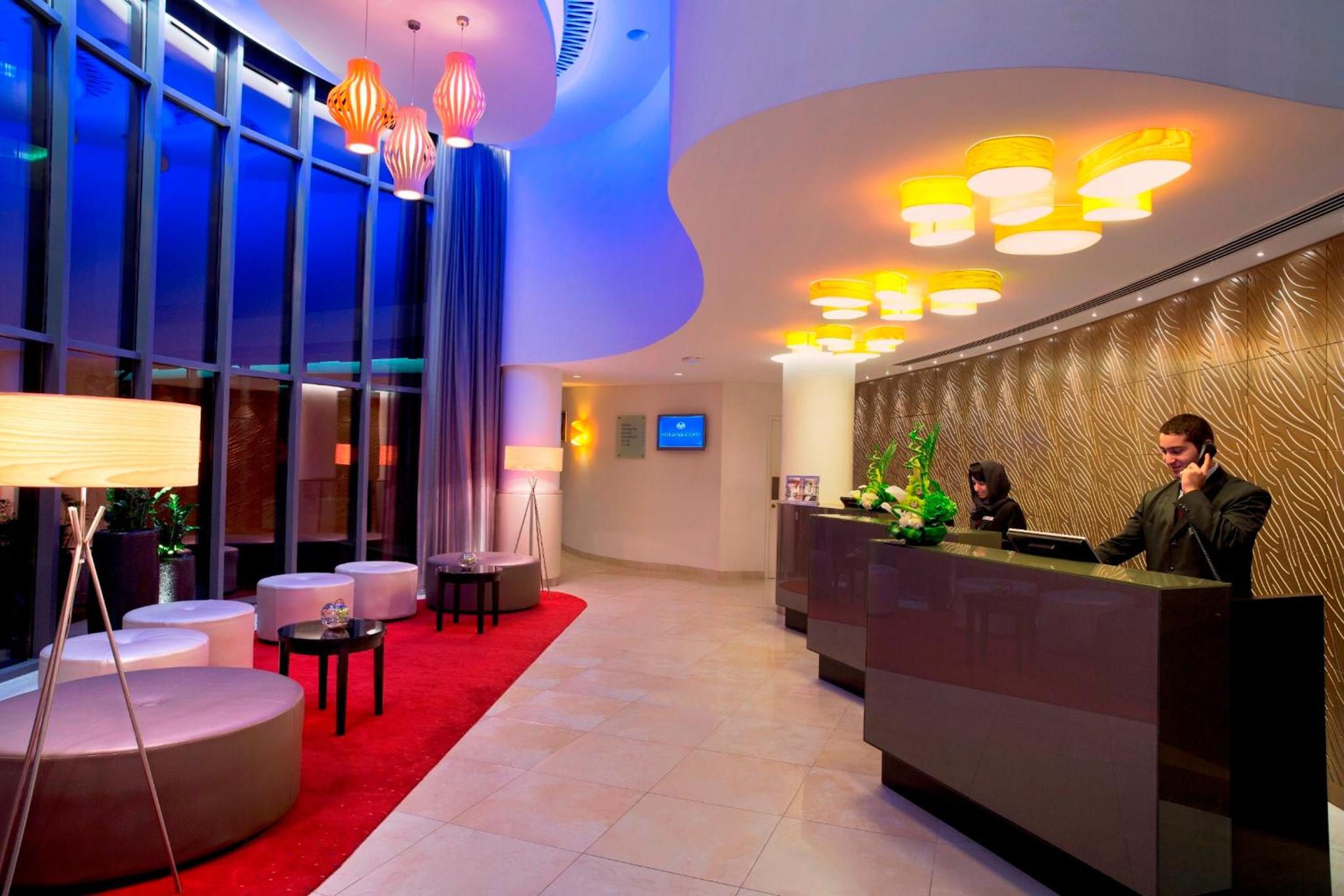 a man standing at a counter in a hotel lobby at Majestic Arjaan by Rotana – Manama in Manama +60 photos