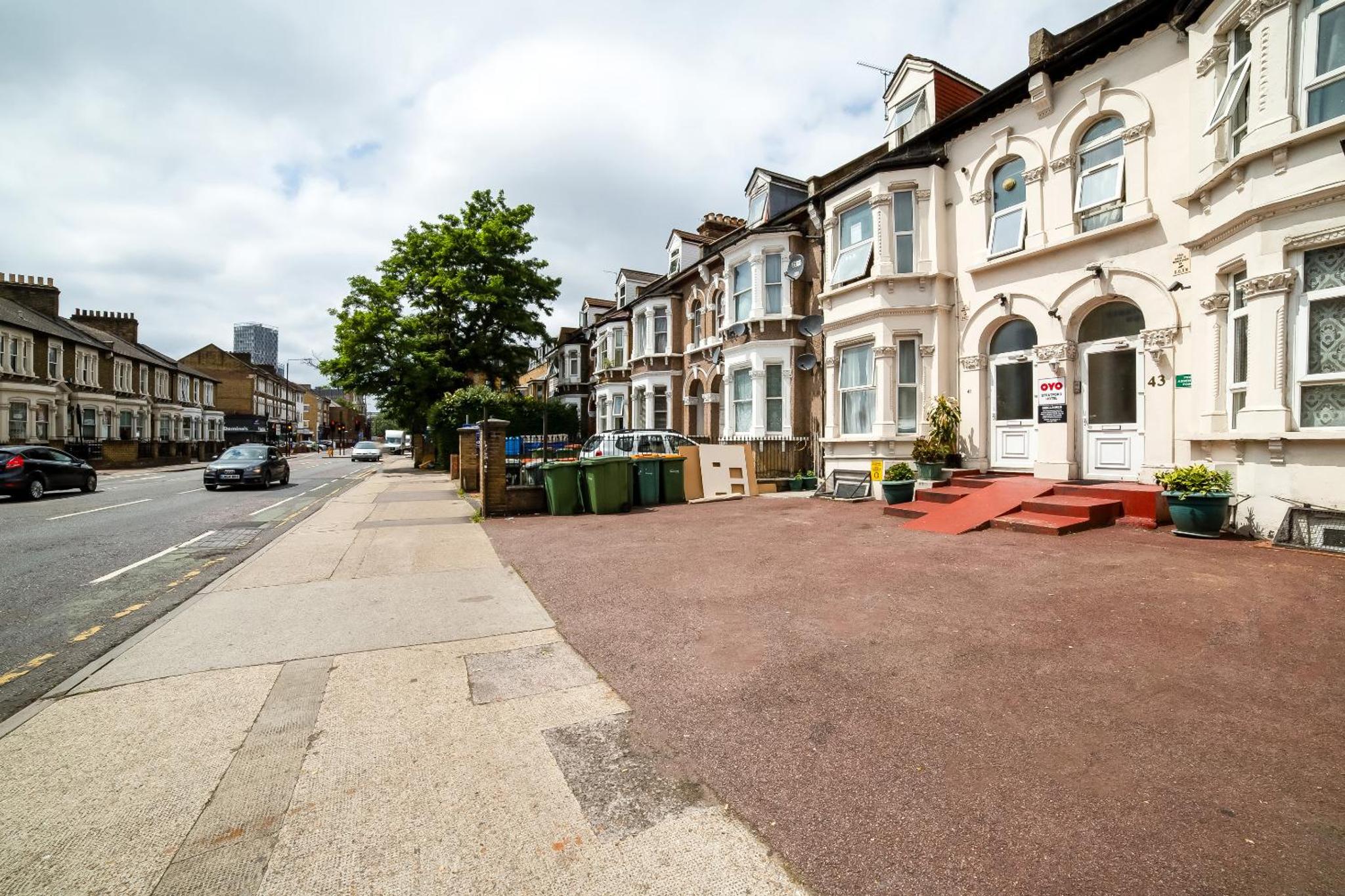 a city street with houses and a sidewalk at Stratford Hotel in London