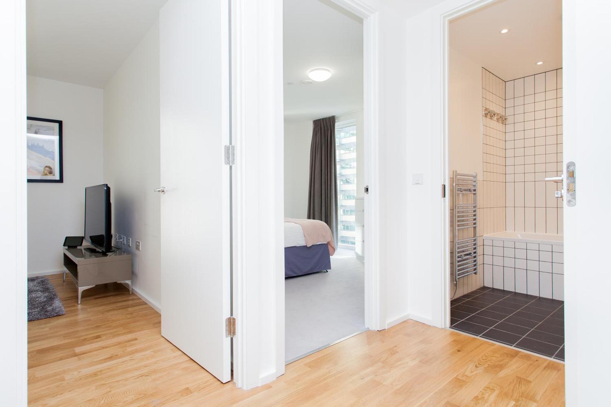 a bedroom with a door leading to a bathroom with a bed at Clover Court by Aeria Apartments in London