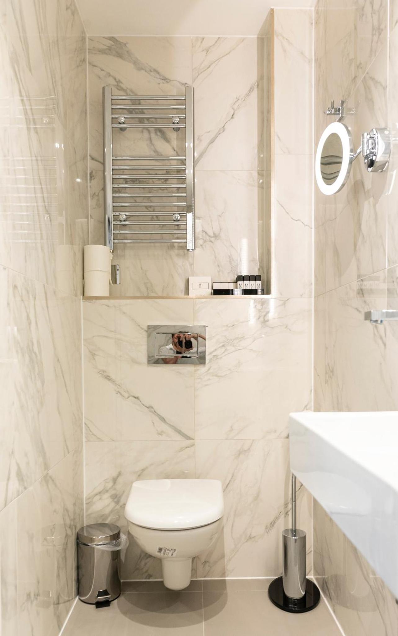 a white bathroom with a toilet and a sink at Messina Studios in London +29 photos