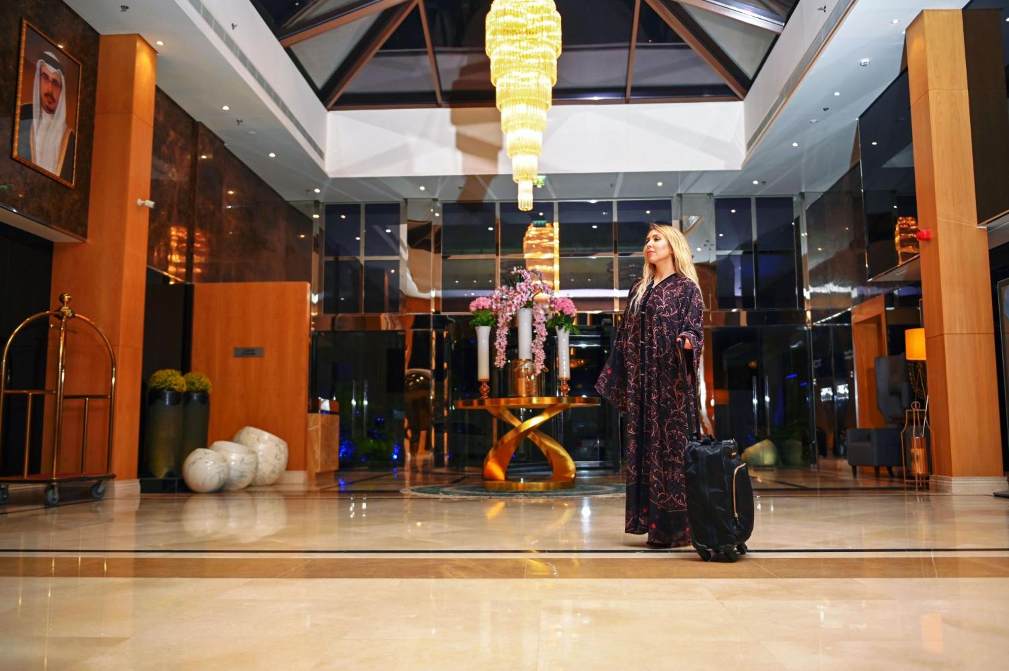 a woman standing in a lobby with a suitcase at Meshal Hotel in Manama +122 photos