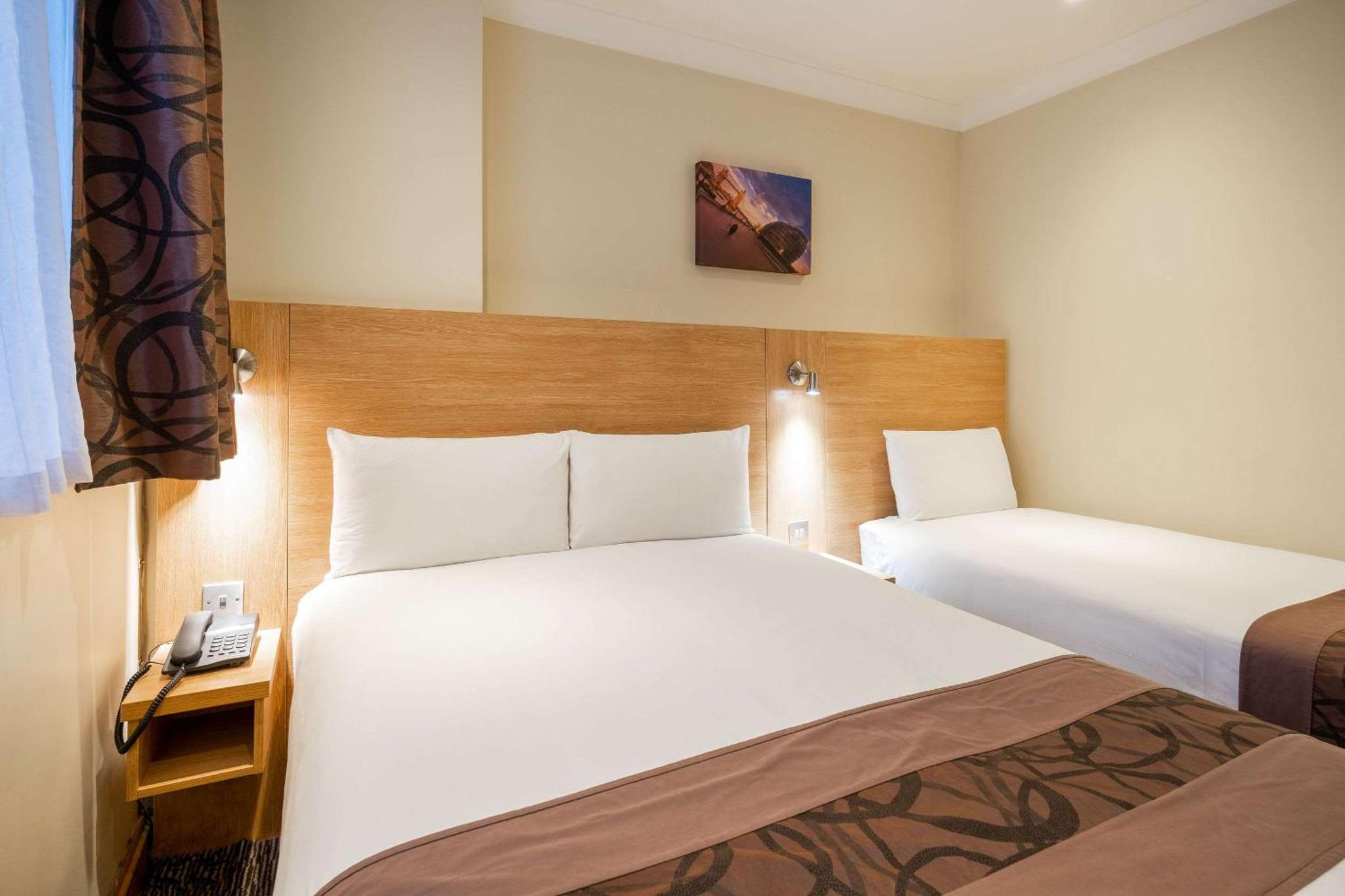 a hotel room with two beds and a phone at Comfort Inn Hyde Park in London