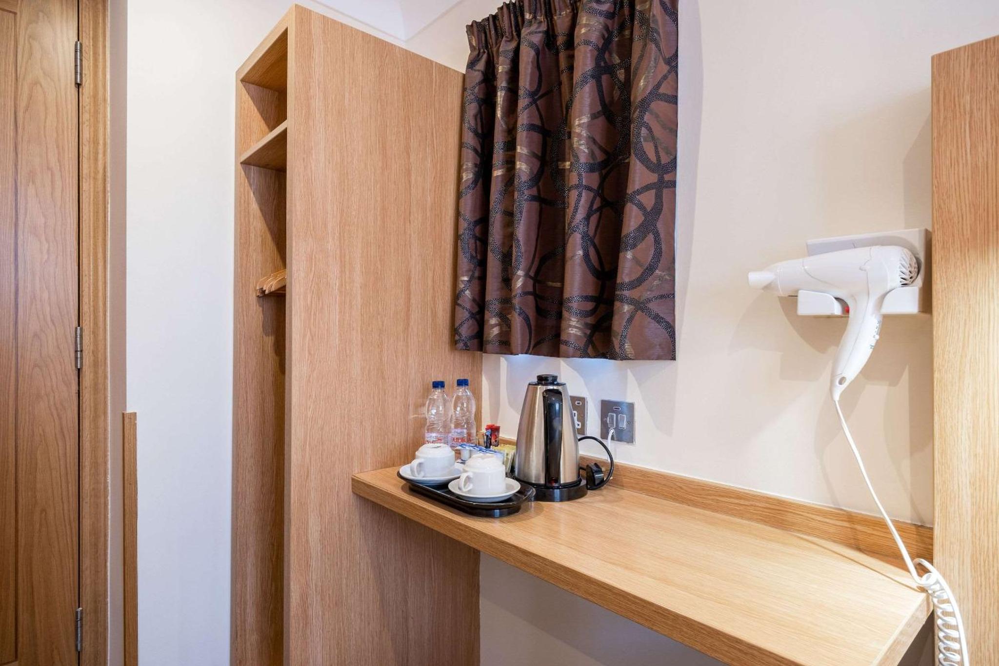 a room with a counter with a coffee maker on it at Comfort Inn Hyde Park in London +20 photos
