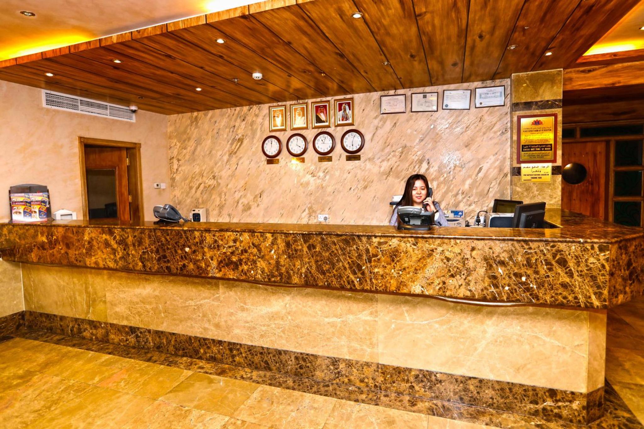 a woman sitting at a counter in a hotel lobby at Sea Shell Hotel in Manama