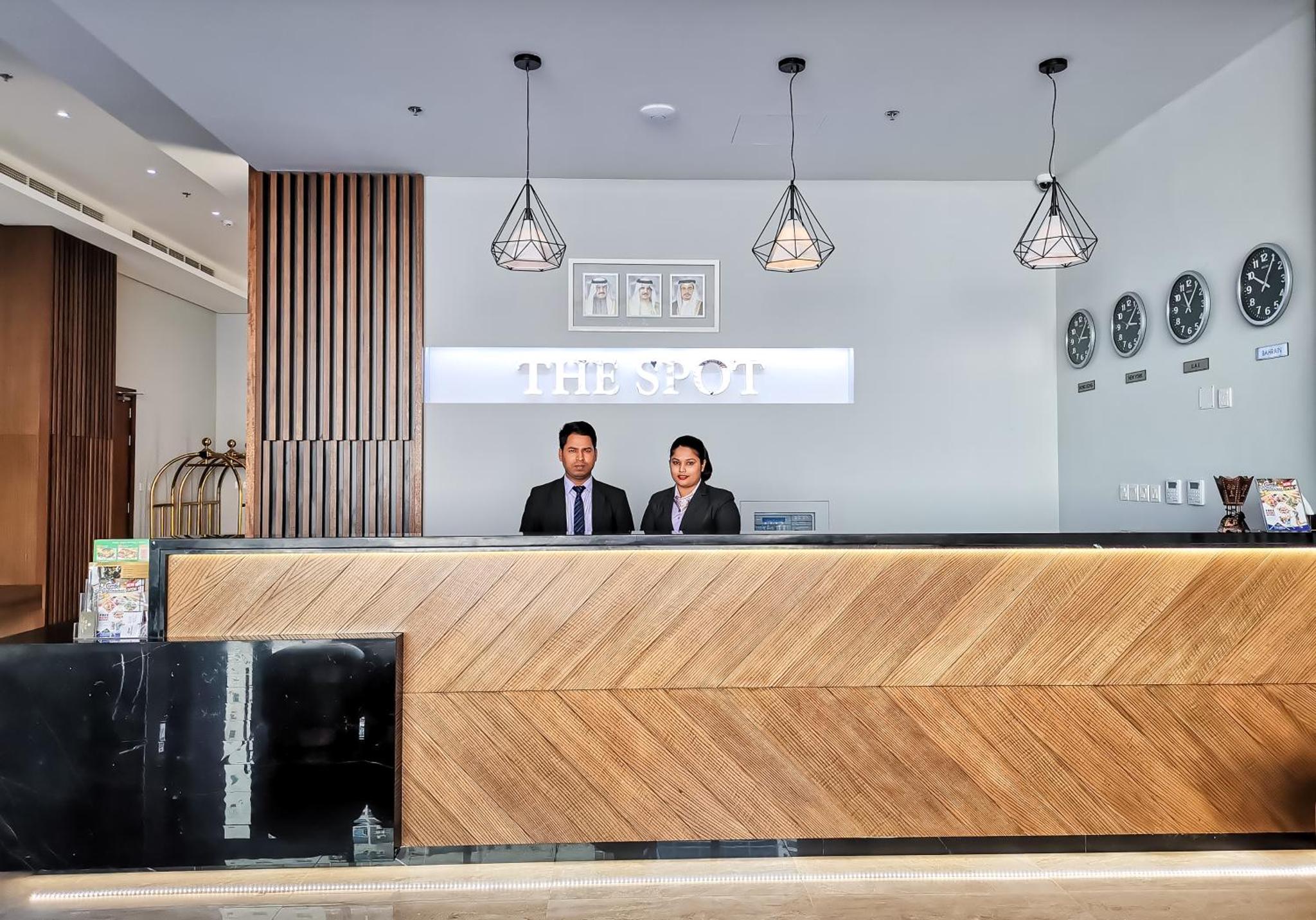 two men standing behind a counter in a store at The Spot Residence in Juffair +33 photos