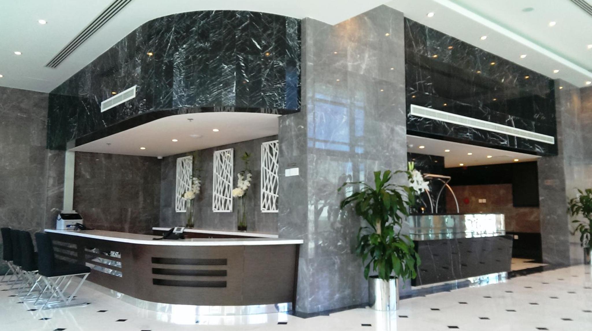 a lobby with a counter in a building at Tulip Hotel & Suites in Manama +36 photos