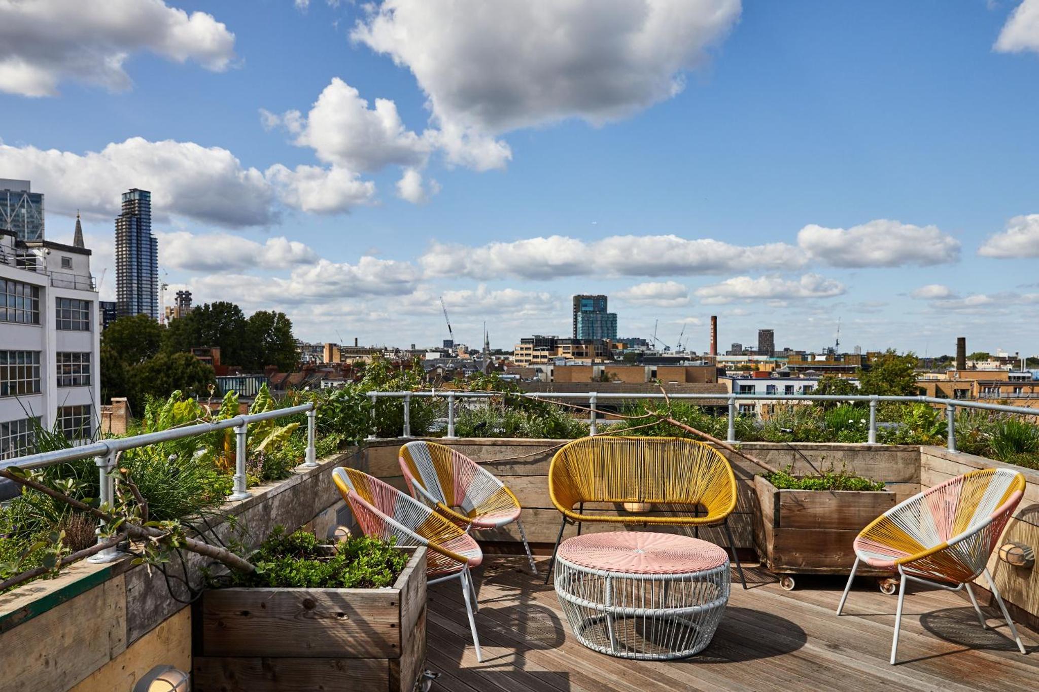 a patio with chairs and a table on a roof at The Buxton in London