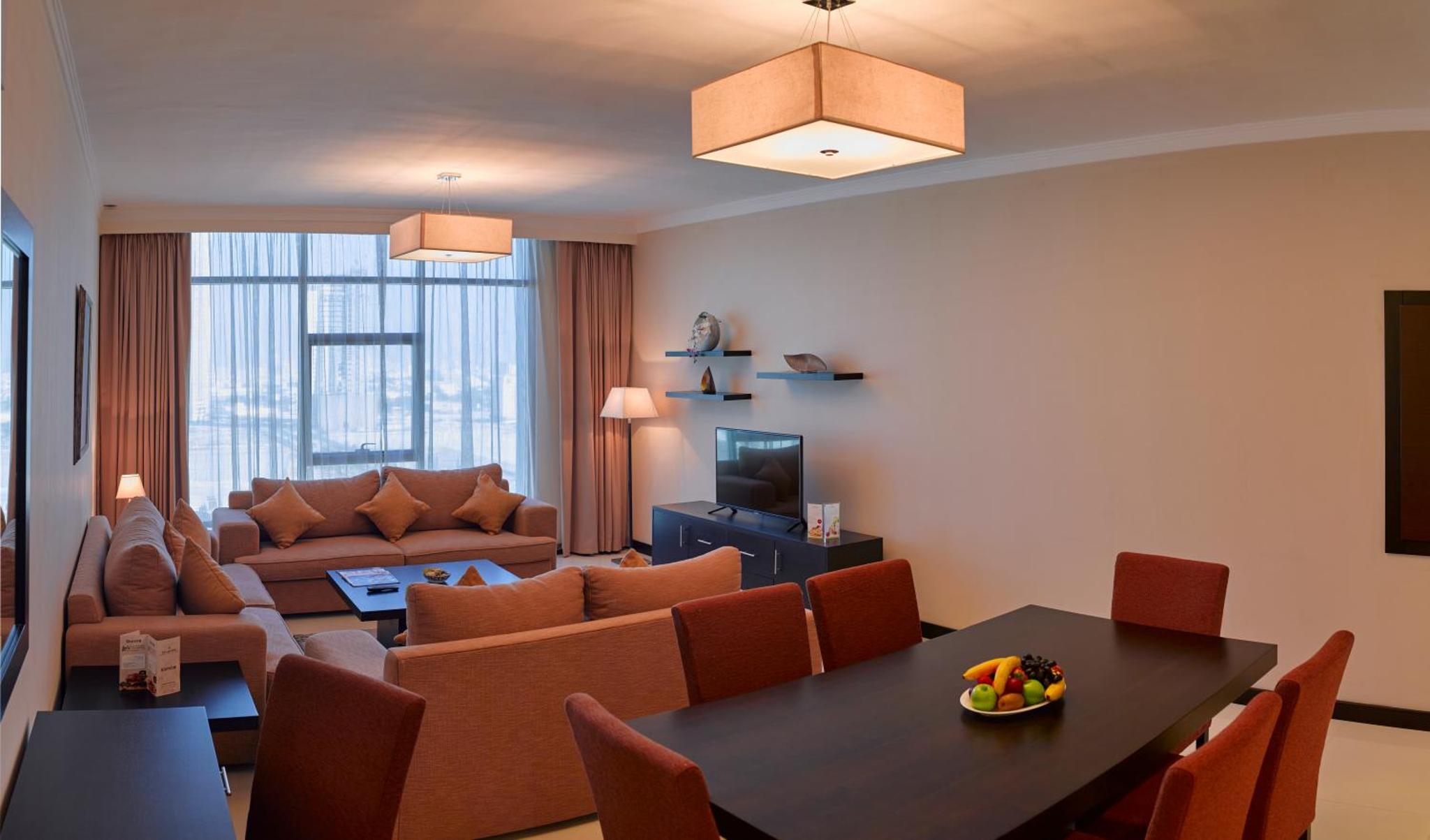 a living room with a table and a couch at Tulip Hotel & Suites in Manama