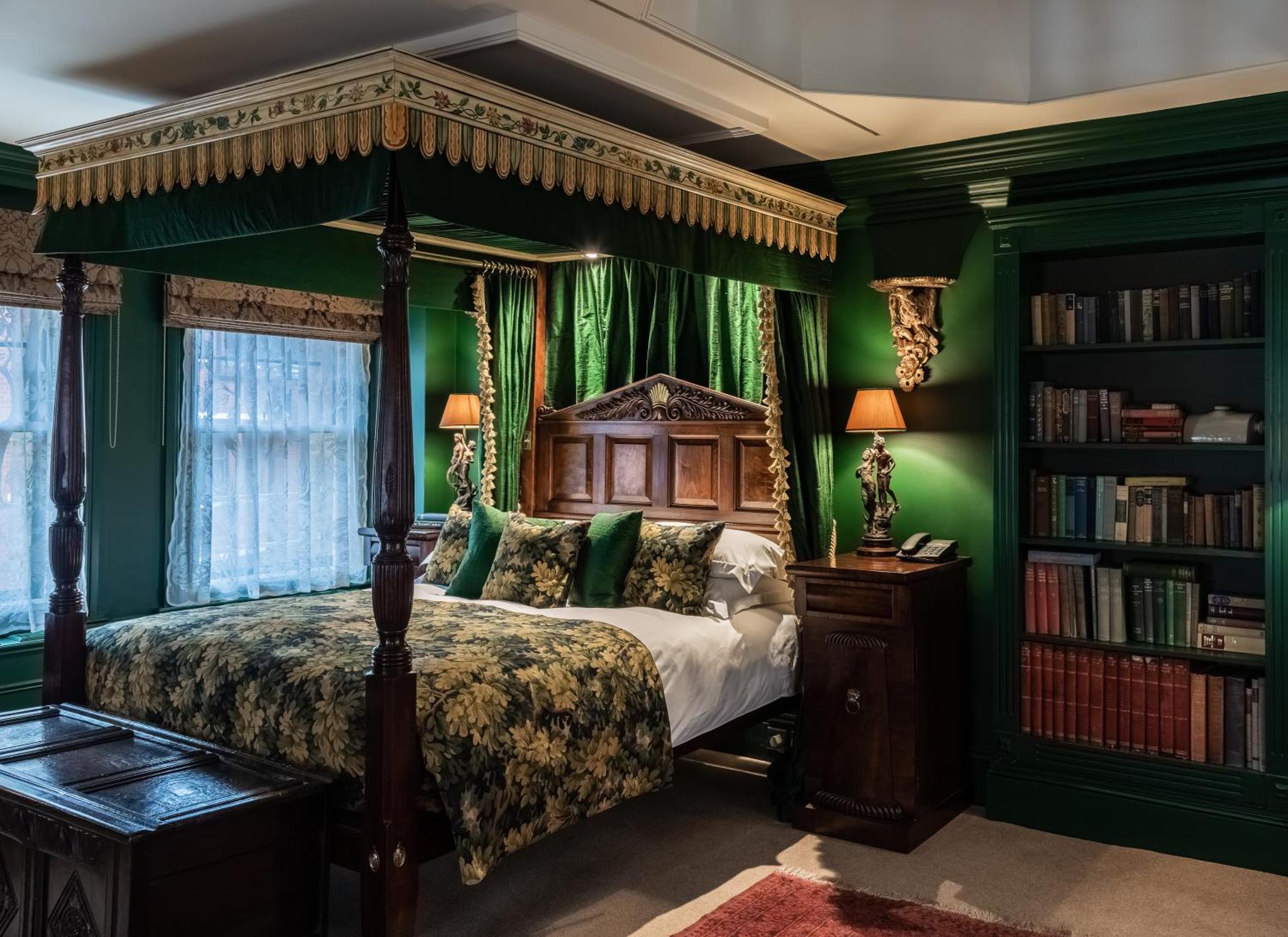 a bedroom with a canopy bed and green walls at The Rookery in London