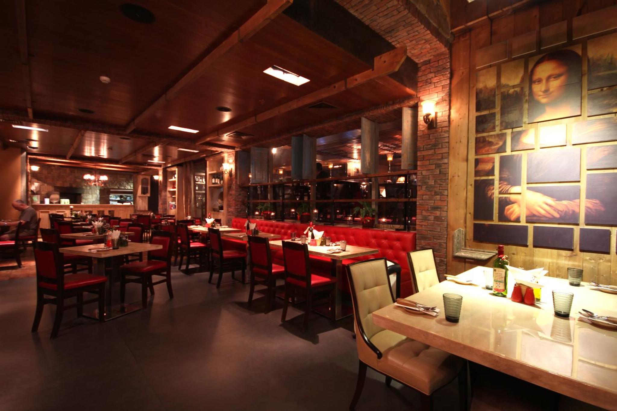 a restaurant with tables and chairs and a bar at Al Safir Hotel in Manama