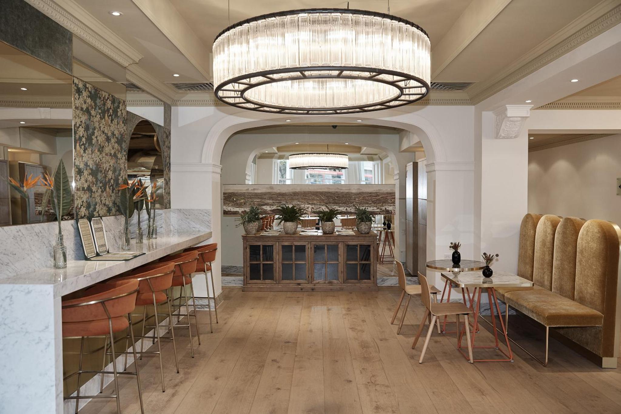 a large room with a table and a chandelier at Meliá London Kensington Member of Meliá Collection in London