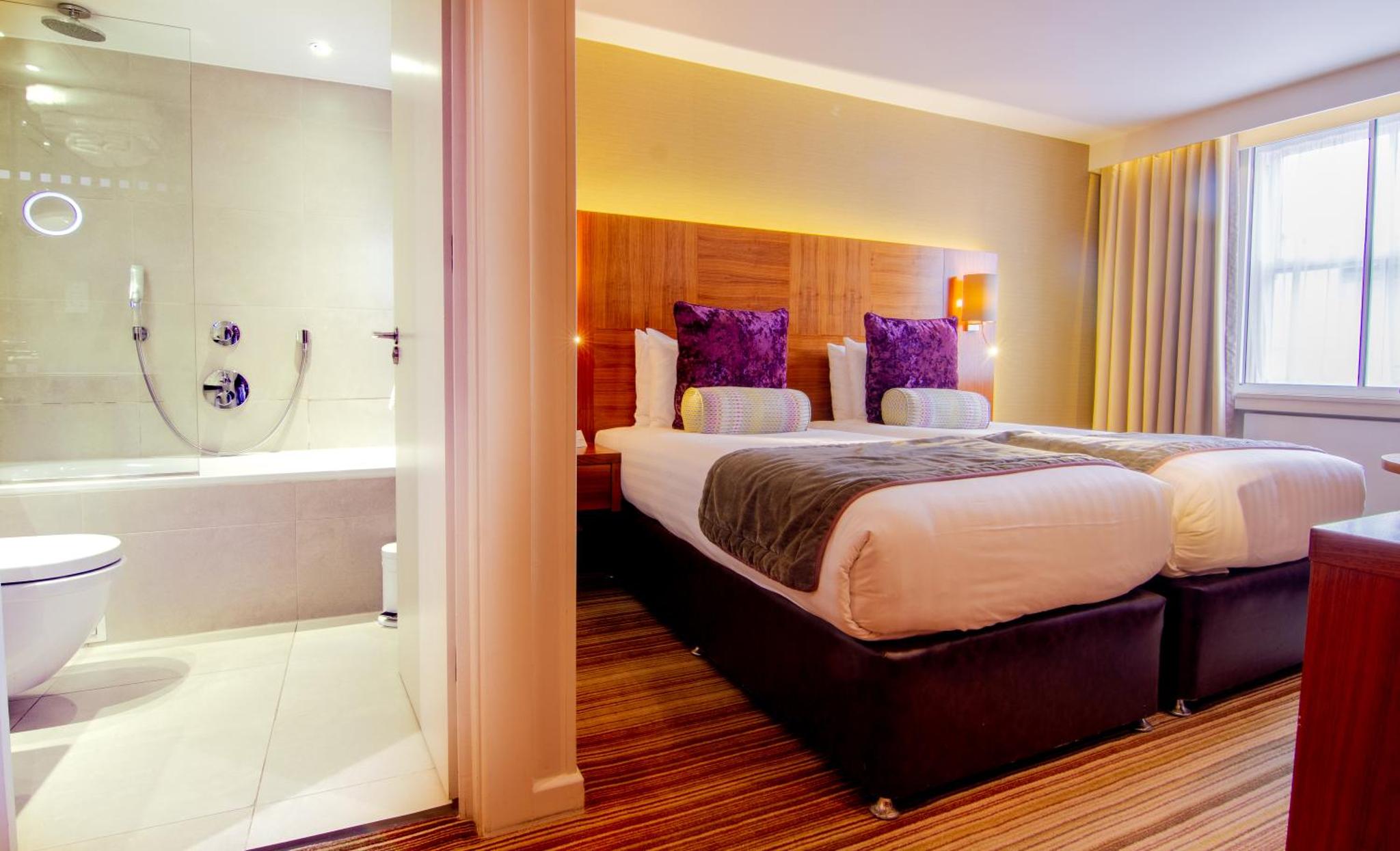 a hotel room with a large bed and a bath tub at Blakemore Hyde Park in London